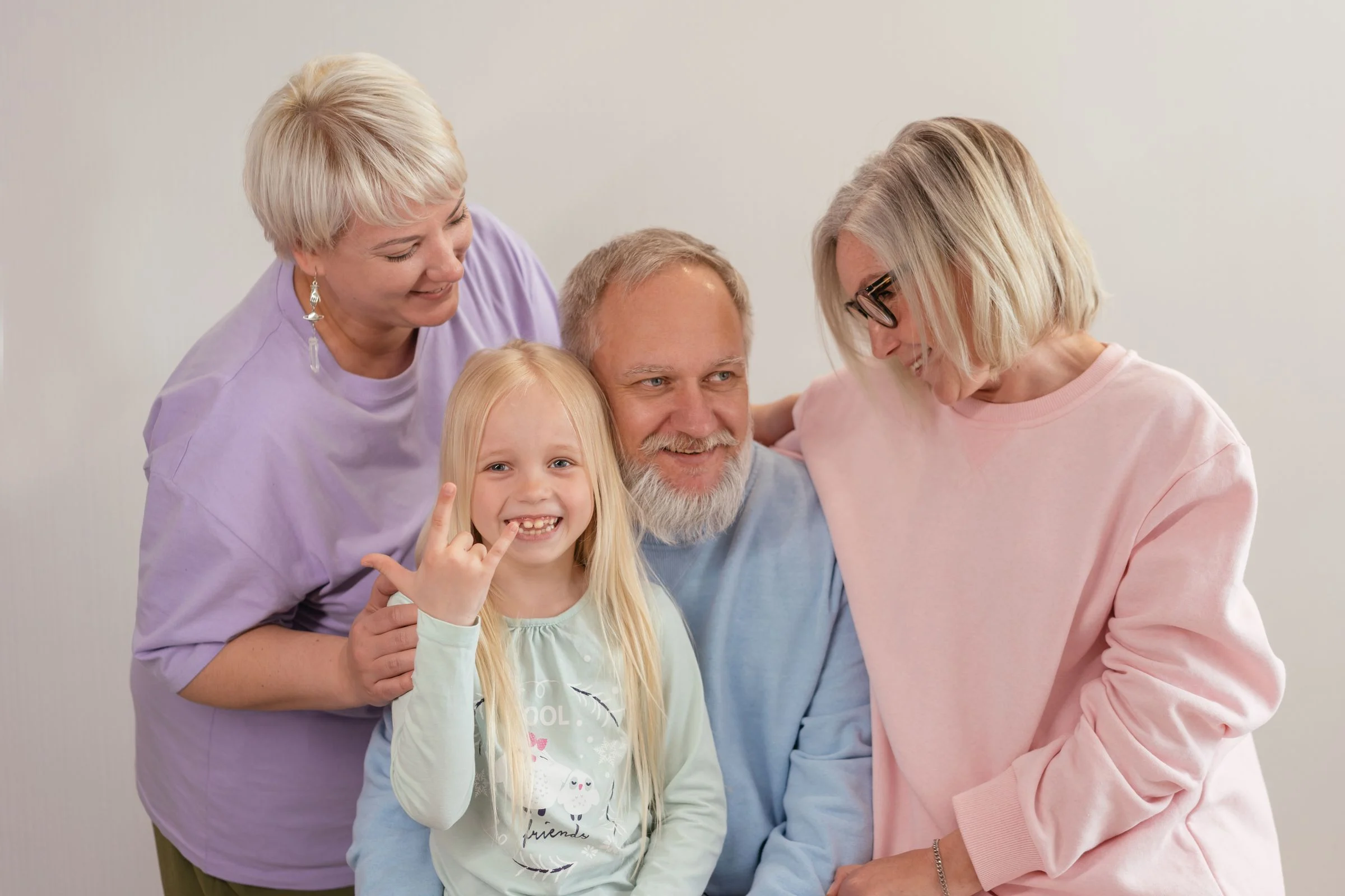 Avô sorridente abraçado pela família e pela neta